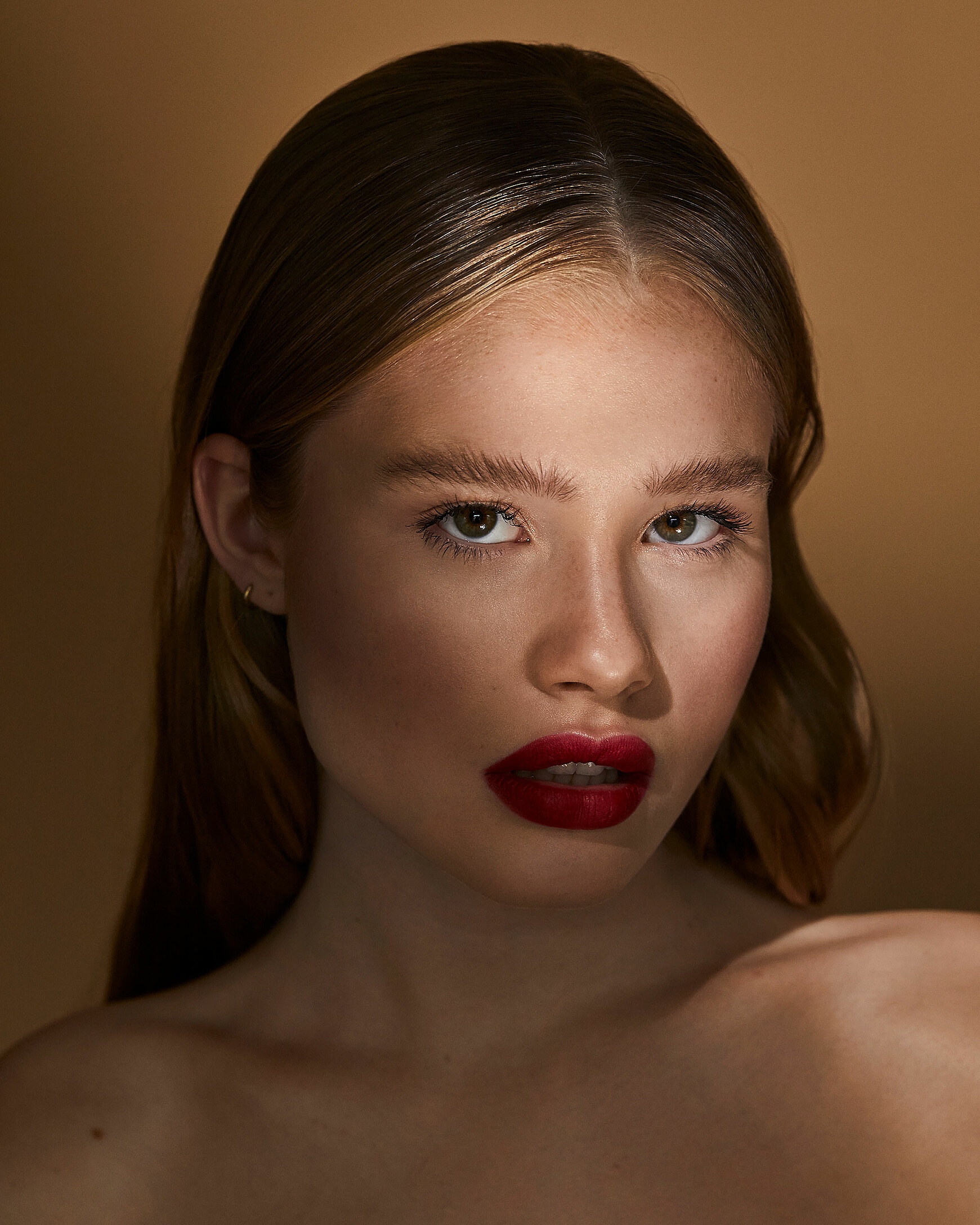 A female blonde model with red lips in a strong pose with sleek hairs