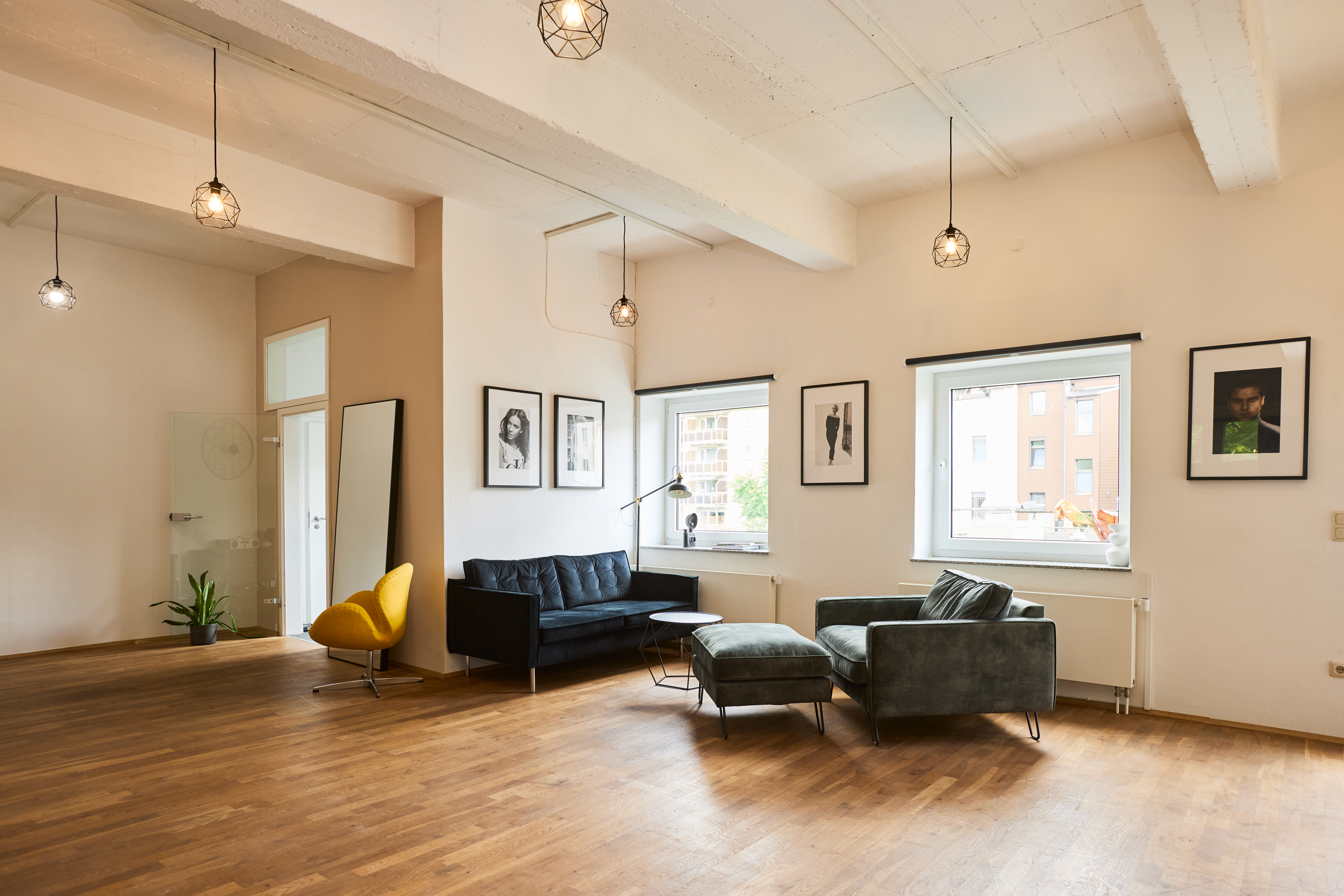 Daylight lounge area of the Wardeski studio with sofa, lounge chairs and large windows