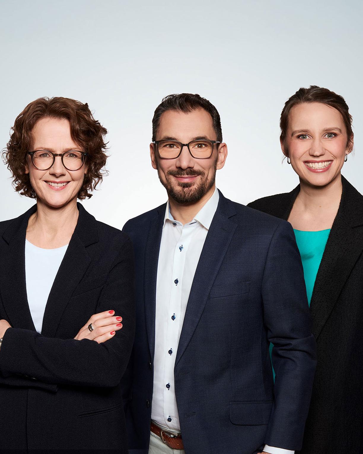 Business Gruppenfoto aus drei Personen die in die Kamera lächeln