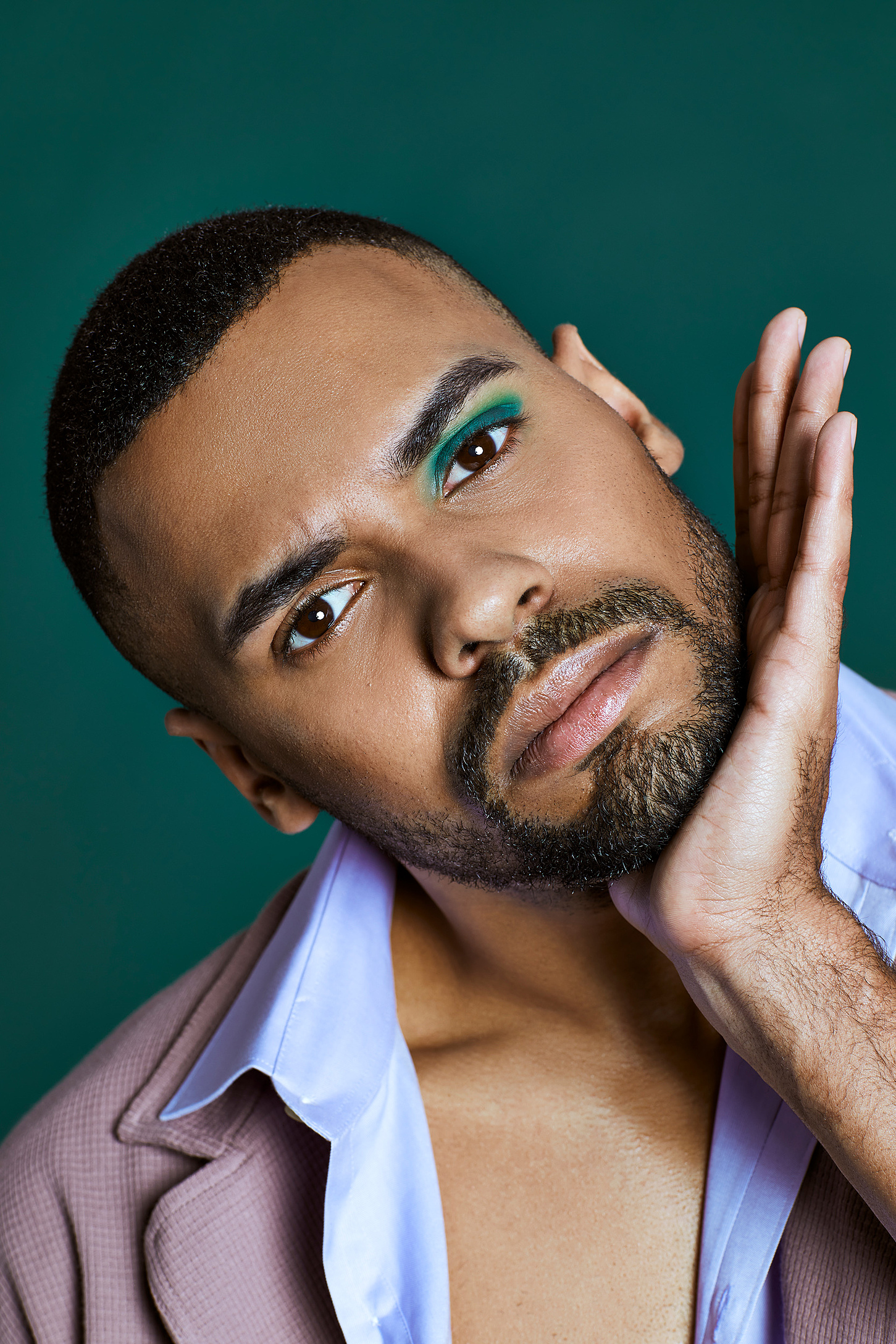 A male model with purple cloths and one green eyeshadow