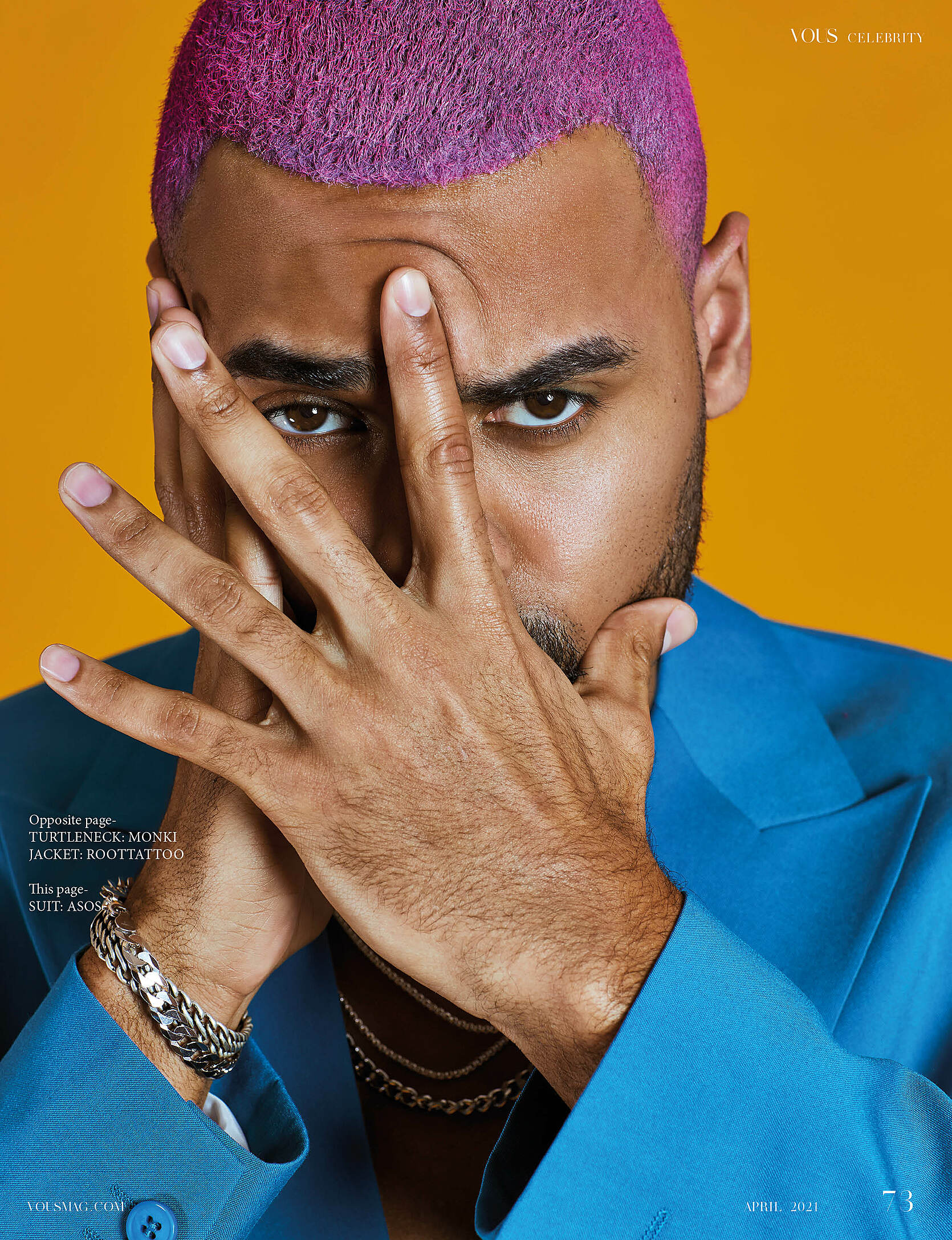 A male model with a blue suit and pink hair
