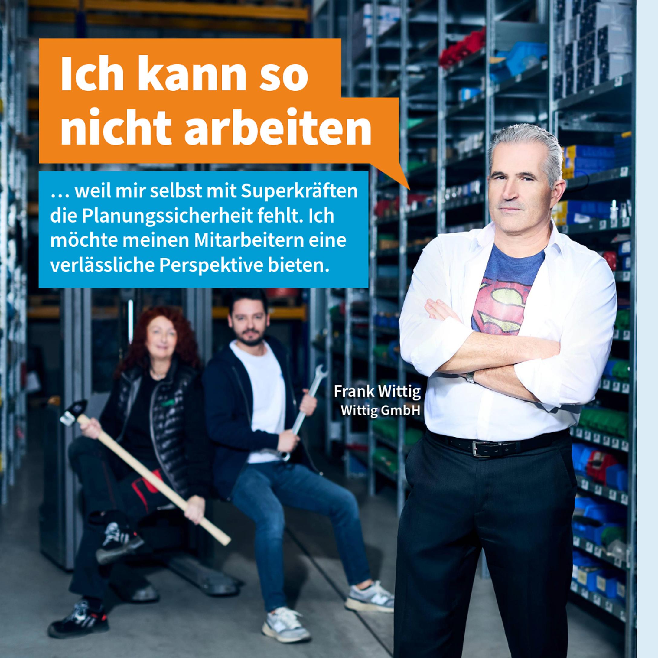 Unternehmer im Superman T-shirt setzt sich für seine Mitarbeiter ein, Lagerhalle